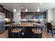 Modern kitchen boasts granite counters, dark cabinetry, stainless steel appliances, and stylish pendant lighting at 26960 E Costilla Dr, Aurora, CO 80016