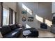 Sun-drenched living room highlights a comfortable couch, large windows, and a stunning floor-to-ceiling tiled fireplace at 26960 E Costilla Dr, Aurora, CO 80016