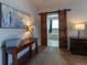 Main bedroom with a wooden console table and ensuite bathroom behind a barn door at 26960 E Costilla Dr, Aurora, CO 80016