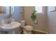 Cozy half-bath with pedestal sink and decorative mirror at 26960 E Costilla Dr, Aurora, CO 80016