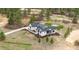 Expansive aerial view showcases a modern farmhouse with lush landscaping and a charming outdoor firepit area at 1567 Arrowpoint Ct, Franktown, CO 80116