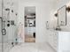 Sleek bathroom features a glass-enclosed shower, walk-in closet and white vanities with black fixtures at 1567 Arrowpoint Ct, Franktown, CO 80116