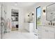 Bright bathroom showcases marble floors, glass shower, dual vanities, contemporary lighting, and walk-in closet at 1567 Arrowpoint Ct, Franktown, CO 80116