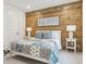 Cozy bedroom showcasing wood accent wall and comfortable bedding at 1567 Arrowpoint Ct, Franktown, CO 80116