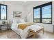 Inviting secondary bedroom offers natural light, modern decor, bench and a side table at 1567 Arrowpoint Ct, Franktown, CO 80116