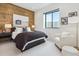 Stylish bedroom with wood accent wall, plush bedding and large window at 1567 Arrowpoint Ct, Franktown, CO 80116