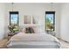 Bright primary bedroom with large windows, modern decor, plush bedding, side tables, and pendant lighting at 1567 Arrowpoint Ct, Franktown, CO 80116