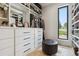 Organized walk-in closet features custom drawers, shelving, and a window for natural light at 1567 Arrowpoint Ct, Franktown, CO 80116