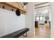 Modern entryway with wood floors, a wooden bench, coat hooks, and a view into the living space at 1567 Arrowpoint Ct, Franktown, CO 80116