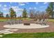 Outdoor fire pit area with chairs surrounded by decorative rocks and grass against a blue sky at 1567 Arrowpoint Ct, Franktown, CO 80116