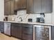 Kitchen area featuring bar with a beverage cooler, modern cabinetry, and marble countertops at 1567 Arrowpoint Ct, Franktown, CO 80116