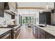 Open-concept kitchen with an island, pendant lighting, and views into the dining area and backyard at 1567 Arrowpoint Ct, Franktown, CO 80116