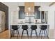 Modern kitchen boasts a marble waterfall island with seating and stainless steel appliances at 1567 Arrowpoint Ct, Franktown, CO 80116