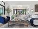 Cozy living room with plush seating, designer rug, and a view to the entry via French doors at 1567 Arrowpoint Ct, Franktown, CO 80116