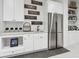 Basement wet bar featuring stainless steel refrigerator, white cabinets and ample counter space at 1567 Arrowpoint Ct, Franktown, CO 80116