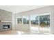 Bright living room with stone fireplace, wood flooring, and sliding glass doors to backyard at 10735 Hanging Lake Pl, Parker, CO 80138