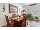 Classic dining room with a wood table set for six, complemented by a large framed picture and natural light from shuttered windows at 19780 W 57Th Ln, Golden, CO 80403