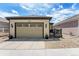 Exterior shot of a home featuring a clean, concrete driveway and a tan garage door with decorative windows at 19780 W 57Th Ln, Golden, CO 80403