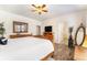 Bright main bedroom with a wooden bed, a dresser, a mirror, and a view into an en-suite bathroom at 19780 W 57Th Ln, Golden, CO 80403