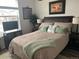 Well-lit bedroom featuring a comfortable bed with decorative pillows and throw, complemented by side tables and wall art at 1784 Cade Ave, Castle Rock, CO 80104