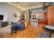 Open living area with kitchen, wood floors, and exposed brick at 1801 Wynkoop St # 205, Denver, CO 80202