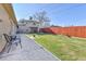 Backyard featuring lush green grass area, stone patio, and privacy fence at 2488 S Zurich Ct, Denver, CO 80219