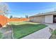 Spacious backyard with a well-maintained lawn, stone patio, and wood fence at 2488 S Zurich Ct, Denver, CO 80219