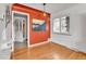Charming dining room featuring hardwood floors, custom lighting, a statement wall, and bright shuttered windows at 2488 S Zurich Ct, Denver, CO 80219