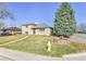 Charming two-story home with a manicured lawn, mature trees, brick landscaping, and a vintage fire hydrant at 2488 S Zurich Ct, Denver, CO 80219