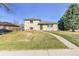 Charming two-story home boasts a well-manicured lawn and a welcoming walkway, complemented by mature trees at 2488 S Zurich Ct, Denver, CO 80219