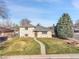 Well-maintained home with a green lawn and mature trees in a quiet neighborhood at 2488 S Zurich Ct, Denver, CO 80219