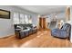 Bright living room with hardwood floors, a comfortable gray sofa, and large windows with lots of natural light at 2488 S Zurich Ct, Denver, CO 80219