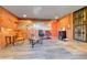 Finished basement living space with brick accent walls and wood-look flooring throughout at 2488 S Zurich Ct, Denver, CO 80219