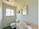 Outdated bathroom featuring toilet, sink, mirror, shelf, and natural light from the window at 1822 Ura Ln, Northglenn, CO 80234