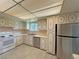 Well-lit kitchen with ample cabinet storage and stainless steel appliances and bright tile flooring at 1822 Ura Ln, Northglenn, CO 80234