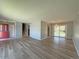 Open-concept living room showing hardwood floors, neutral paint, staircase, and sliding doors to backyard at 1822 Ura Ln, Northglenn, CO 80234