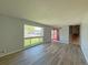 Open-concept living room showing hardwood floors, neutral paint, staircase, and a large front window at 1822 Ura Ln, Northglenn, CO 80234