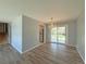 Open-concept living room showing hardwood floors, neutral paint, staircase, and sliding doors to backyard at 1822 Ura Ln, Northglenn, CO 80234