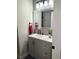 Well-lit bathroom features a vanity with gray cabinets, modern fixtures, and decorative mirror at 21 Douglas N Dr, Broomfield, CO 80020