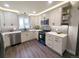 Modern kitchen features white cabinets, stainless steel appliances, gray subway tile backsplash, and stylish lighting at 21 Douglas N Dr, Broomfield, CO 80020