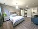 Spacious main bedroom features modern accent wall, stylish light fixture, and sliding barn door to ensuite bath at 21 Douglas N Dr, Broomfield, CO 80020