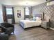 Bright main bedroom with geometric accent wall, stylish light fixtures, and comfortable seating area at 21 Douglas N Dr, Broomfield, CO 80020