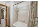 Bathroom showcasing neutral tile, a bathtub with shower, and modern fixtures at 8065 W Fremont Dr, Littleton, CO 80128