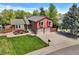 Aerial view of split-level home with well-kept lawn, mature trees, and attached two-car garage at 8065 W Fremont Dr, Littleton, CO 80128