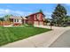 Beautiful split-level home with a well-manicured lawn, mature tree, and an attached two-car garage at 8065 W Fremont Dr, Littleton, CO 80128