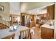 Open kitchen with stainless steel appliances and warm wood cabinetry adjacent to the dining and living spaces at 8065 W Fremont Dr, Littleton, CO 80128