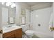 Bright bathroom with a shower-tub combo, wooden vanity, and classic white tile and fresh white towels at 13635 E Yale Ave # D, Aurora, CO 80014