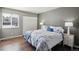Cozy bedroom featuring a large window, closet and a beautifully decorated bed with blue floral comforter and matching pillows at 13635 E Yale Ave # D, Aurora, CO 80014