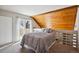 Unique bedroom loft with wood paneled wall, gray bed and balcony access with natural light at 13635 E Yale Ave # D, Aurora, CO 80014