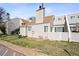 Exterior view of the townhouse, featuring vinyl siding, well-maintained landscaping, and a grassy area at 13635 E Yale Ave # D, Aurora, CO 80014